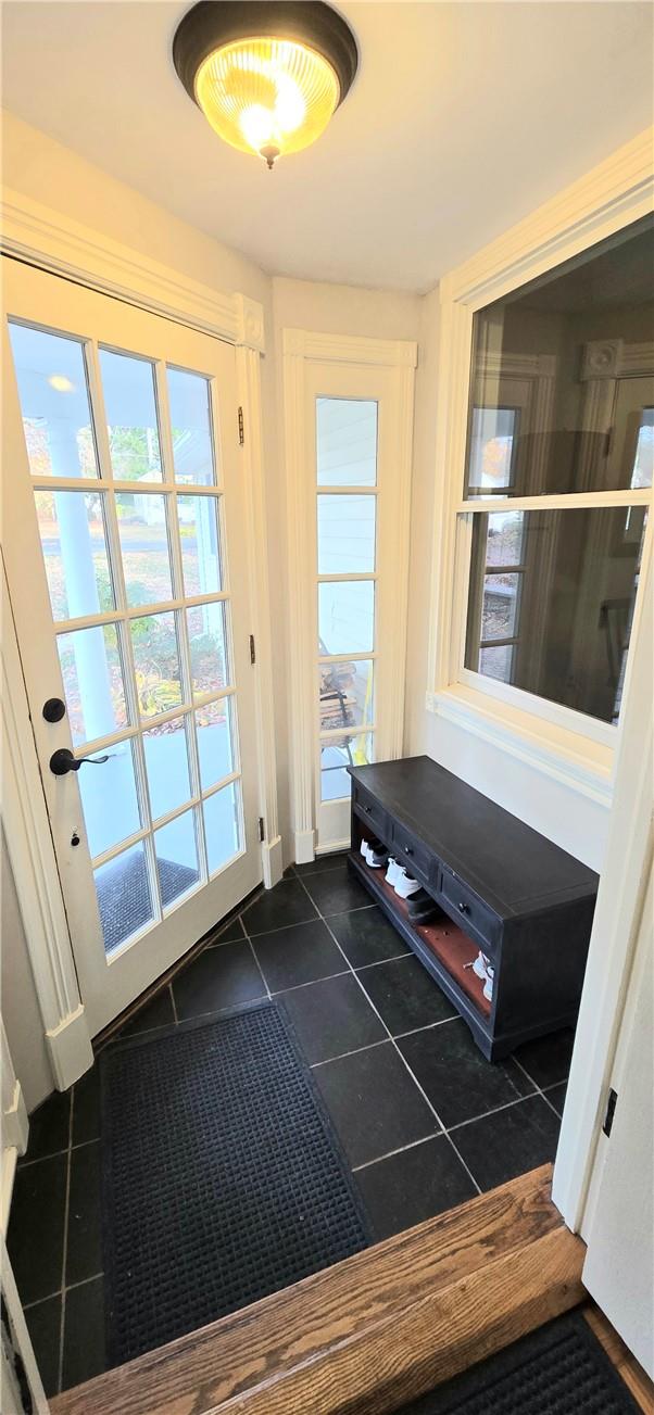 doorway with dark tile patterned floors