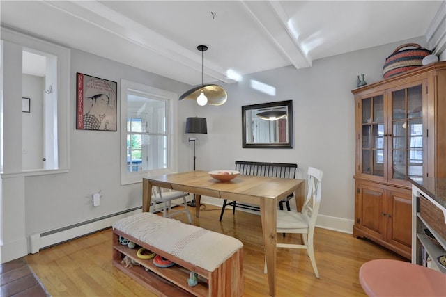 dining space with baseboard heating, light hardwood / wood-style flooring, and beamed ceiling