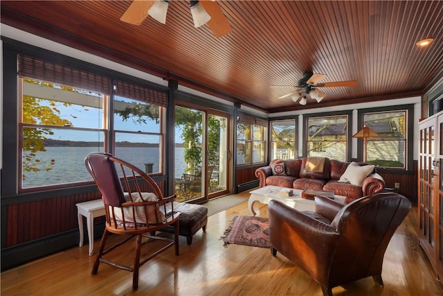 sunroom / solarium featuring ceiling fan and a water view