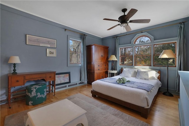 bedroom with ceiling fan, light hardwood / wood-style floors, and crown molding