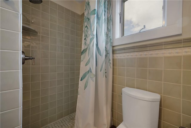 bathroom featuring tile walls, walk in shower, and toilet