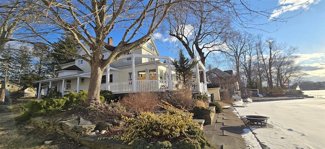 view of side of property featuring covered porch