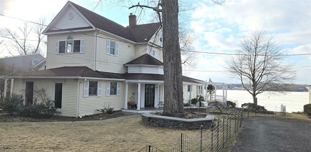 view of front facade featuring a front yard and a water view