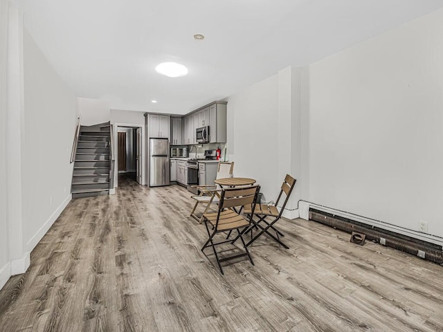 dining area with baseboard heating and light hardwood / wood-style floors