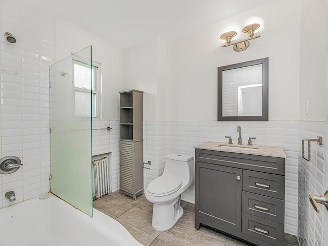 full bathroom with vanity, tile patterned flooring, tiled shower / bath combo, toilet, and tile walls