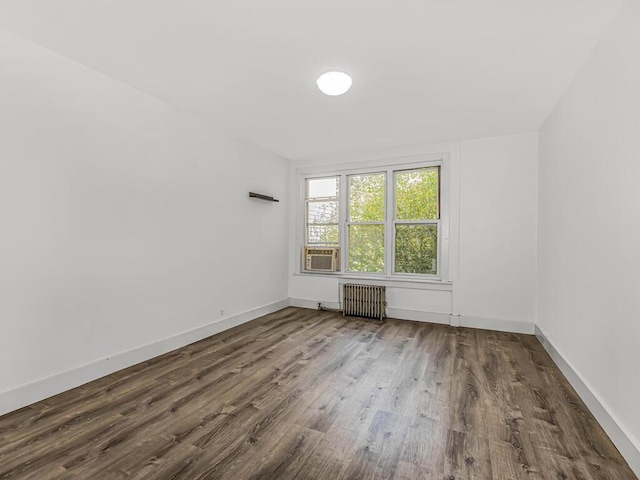 unfurnished room with dark hardwood / wood-style floors and radiator