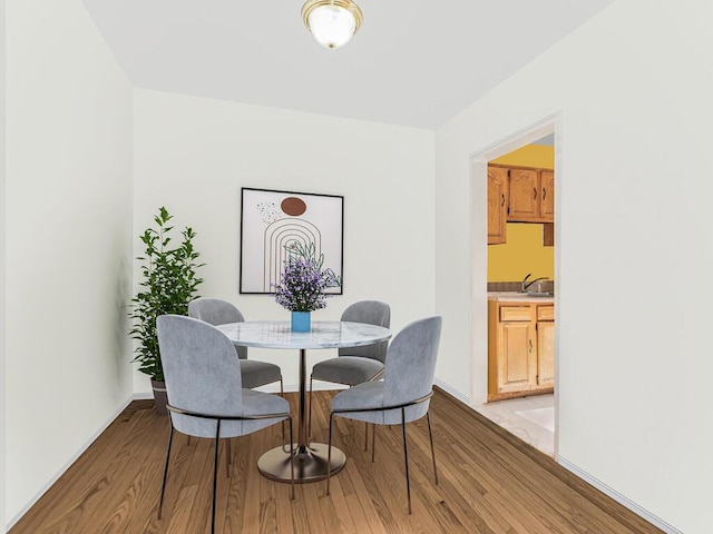 dining space with light wood-type flooring and sink