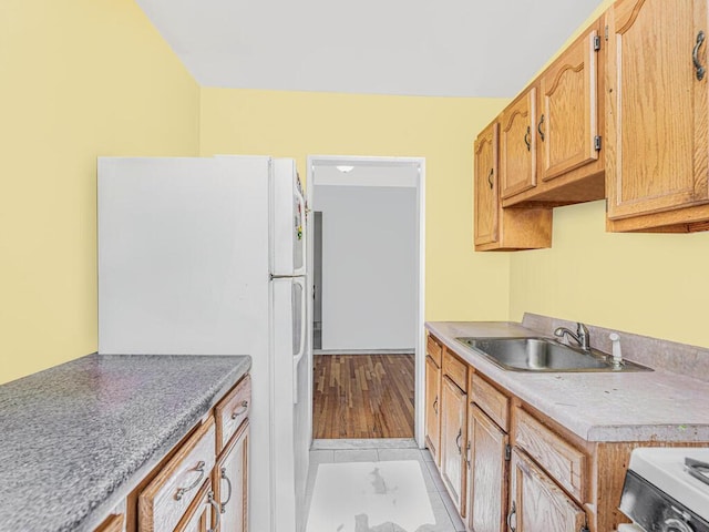 kitchen with sink, white appliances, and light hardwood / wood-style flooring