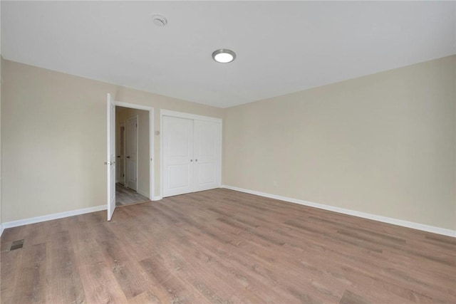 unfurnished bedroom featuring light hardwood / wood-style floors and a closet