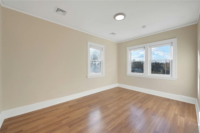 unfurnished room featuring hardwood / wood-style floors and crown molding