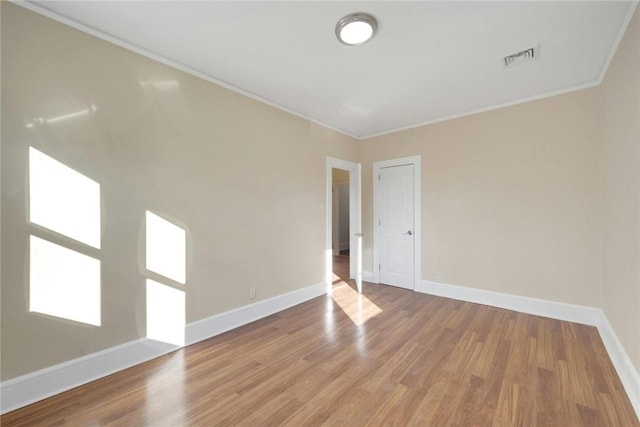 unfurnished room with hardwood / wood-style floors and ornamental molding