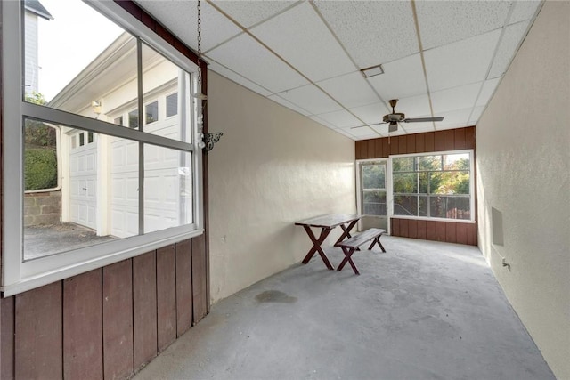 unfurnished sunroom with a paneled ceiling and ceiling fan