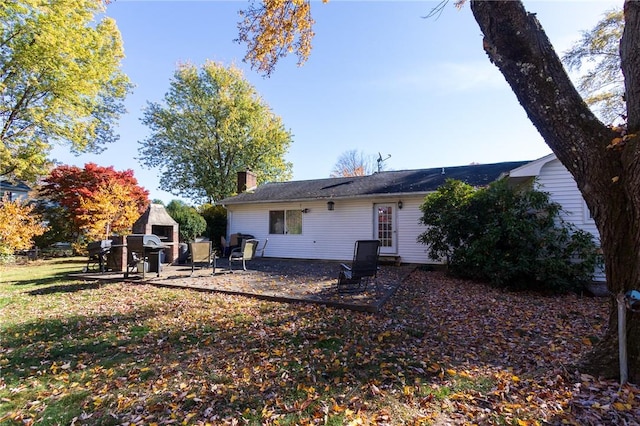 back of house featuring a fireplace and a patio