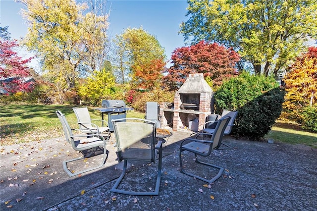 view of patio / terrace featuring an outdoor brick fireplace and a grill