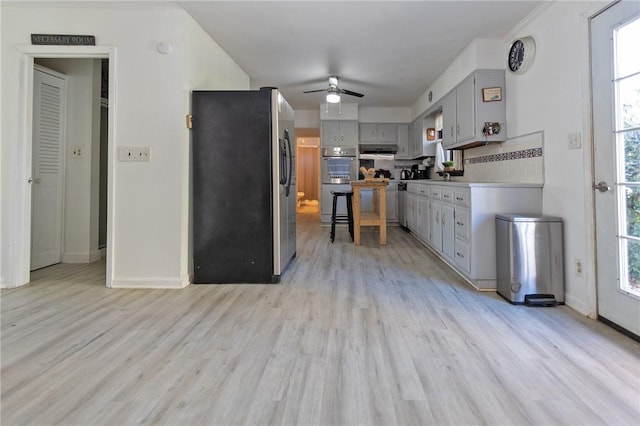 kitchen featuring gray cabinetry, a healthy amount of sunlight, stainless steel appliances, and light wood-type flooring