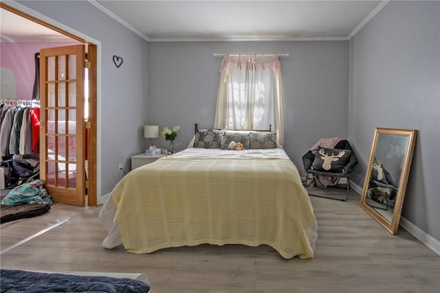 bedroom featuring light wood-type flooring and crown molding