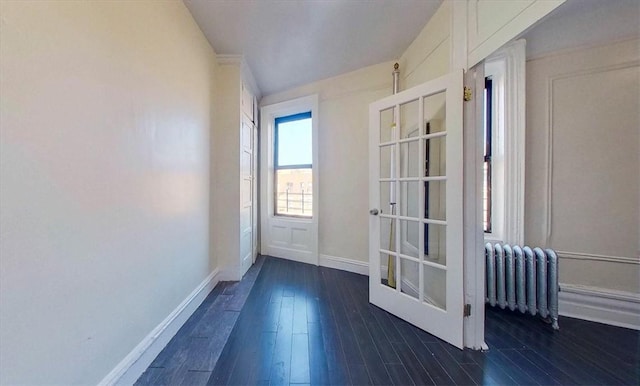 doorway with dark hardwood / wood-style floors and radiator heating unit