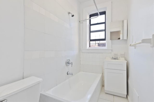 full bathroom with sink, tile walls, tile patterned flooring, toilet, and tiled shower / bath