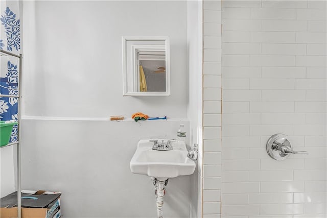 bathroom with a tile shower and sink