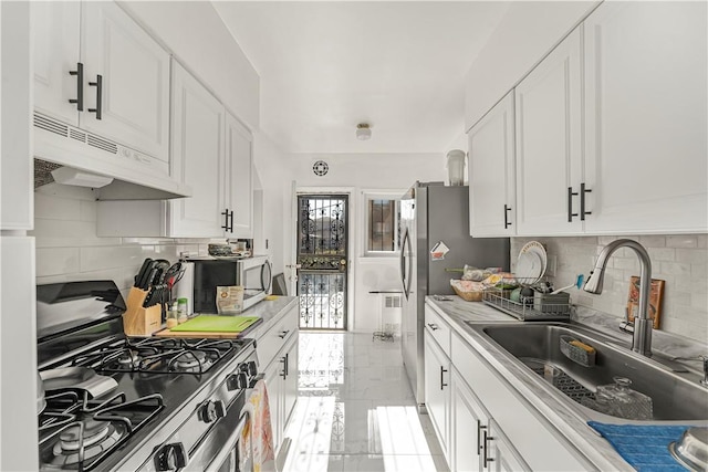 kitchen with white cabinets, appliances with stainless steel finishes, and sink