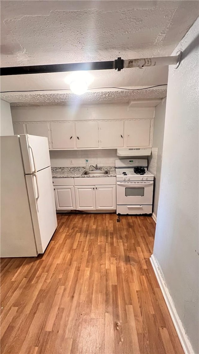 kitchen featuring white appliances, sink, light wood-type flooring, a textured ceiling, and white cabinetry