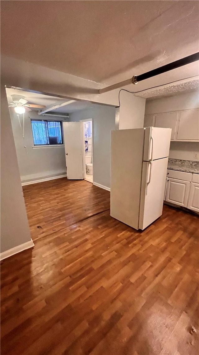 basement with hardwood / wood-style floors and white fridge