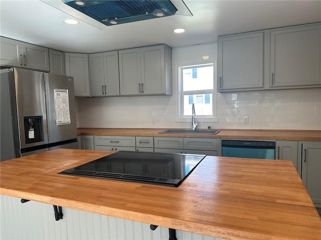 kitchen with appliances with stainless steel finishes, sink, gray cabinetry, and wood counters