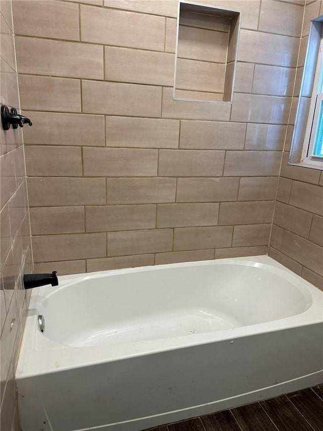 bathroom with hardwood / wood-style flooring and a bathtub