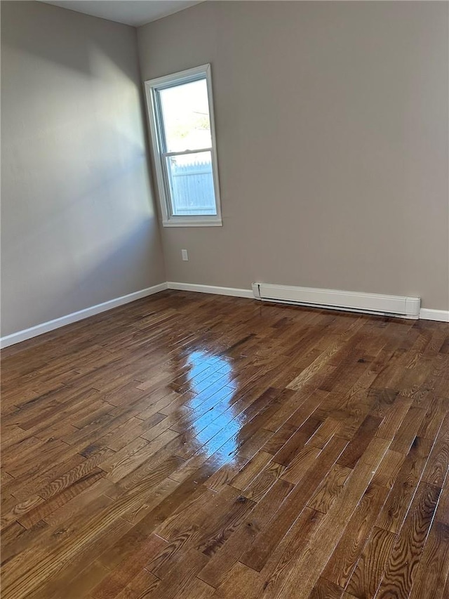 unfurnished room featuring dark hardwood / wood-style floors and baseboard heating