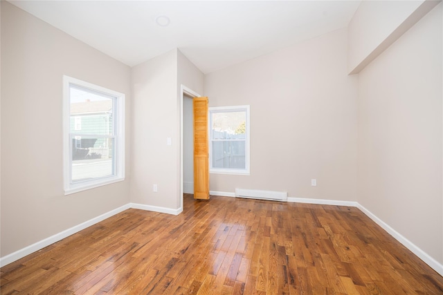 unfurnished bedroom featuring hardwood / wood-style flooring and a baseboard radiator