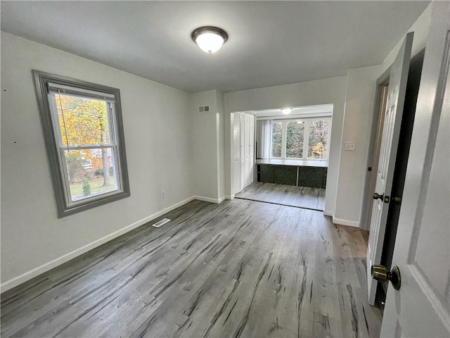 unfurnished bedroom with multiple windows and light hardwood / wood-style floors