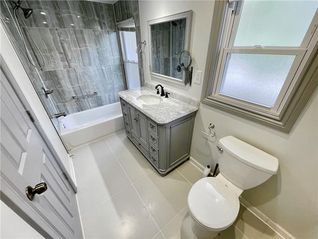 full bathroom with tiled shower / bath, tile patterned floors, vanity, and toilet