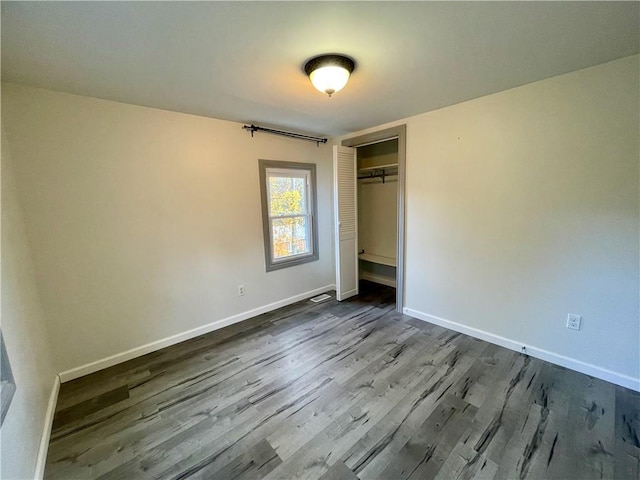 unfurnished bedroom with hardwood / wood-style floors and a closet