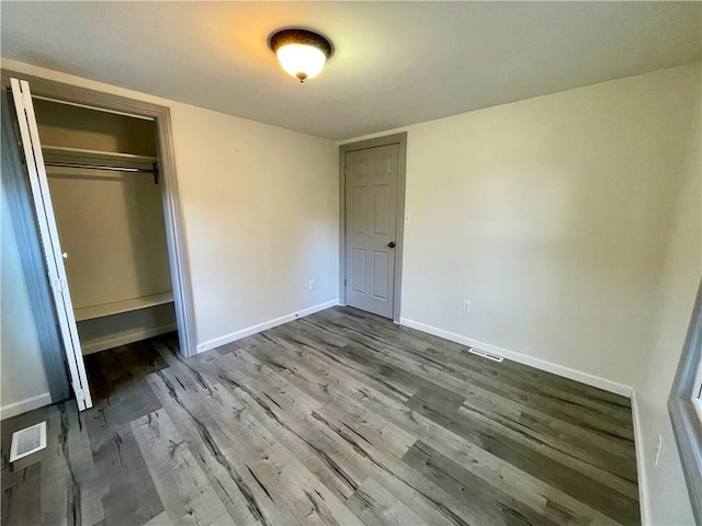 unfurnished bedroom featuring hardwood / wood-style flooring and a closet