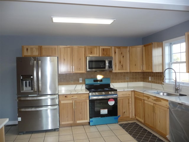 kitchen with light tile patterned flooring, appliances with stainless steel finishes, backsplash, and sink