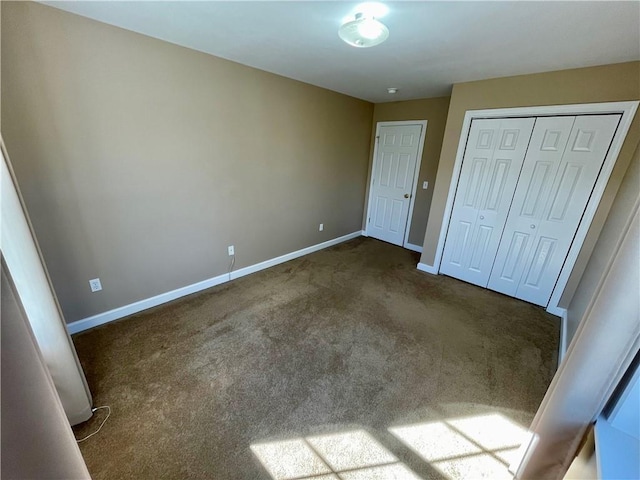 unfurnished bedroom with a closet and dark carpet