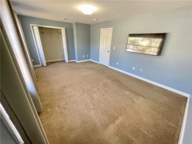 unfurnished bedroom featuring light carpet and a closet