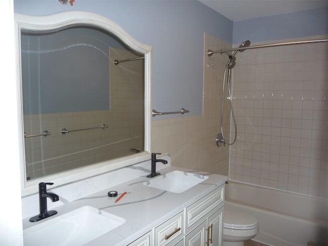 full bathroom featuring vanity, tiled shower / bath combo, and toilet