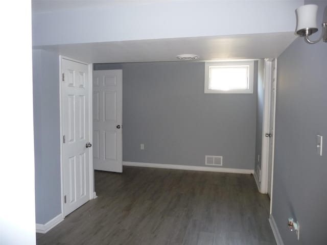 unfurnished room featuring dark hardwood / wood-style flooring and an inviting chandelier