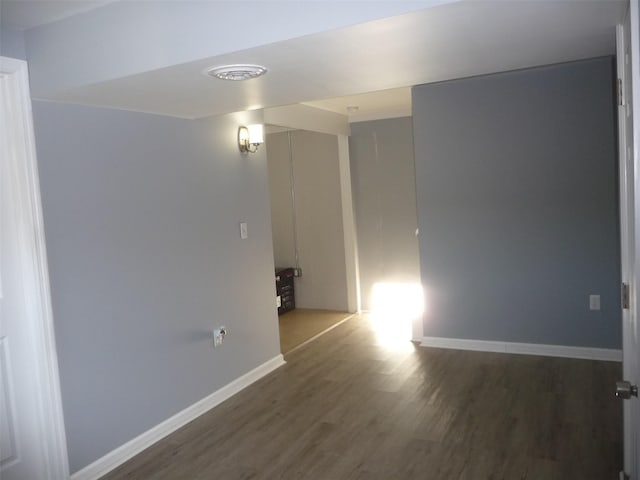 unfurnished room with dark hardwood / wood-style flooring