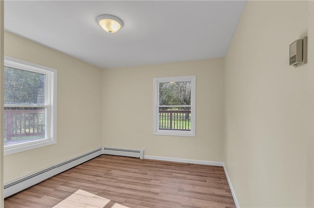 spare room featuring a baseboard radiator and light hardwood / wood-style flooring