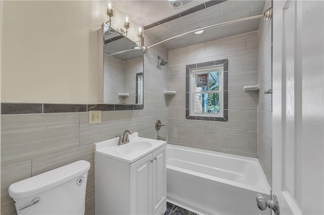 full bathroom with vanity, toilet, tile walls, and tiled shower / bath combo