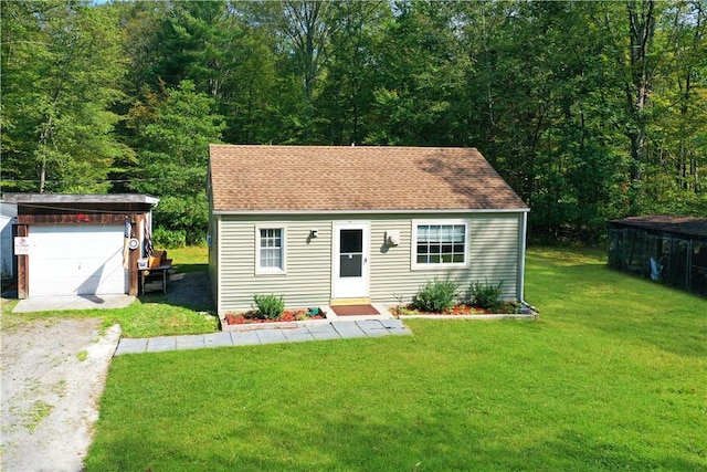 view of front of house with a garage, a front lawn, and an outdoor structure