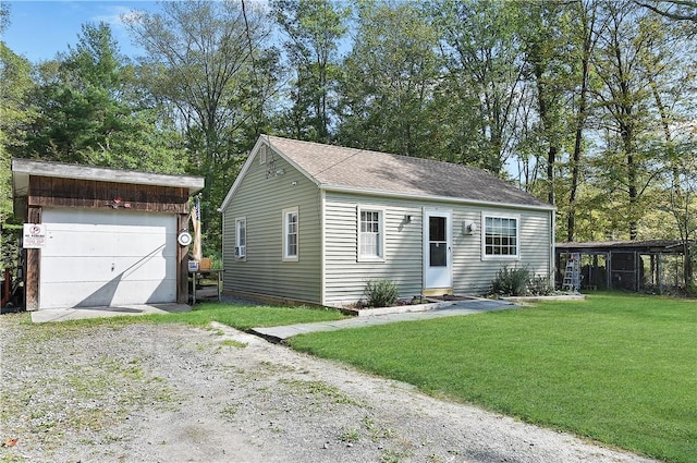 view of front of house with an outbuilding, a front yard, and a garage