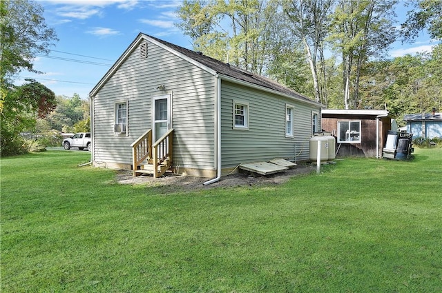 rear view of house with a lawn and cooling unit