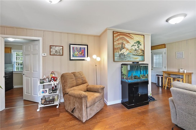 living area featuring wood-type flooring and crown molding