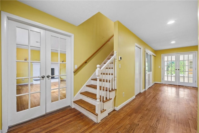 stairs featuring french doors and wood-type flooring