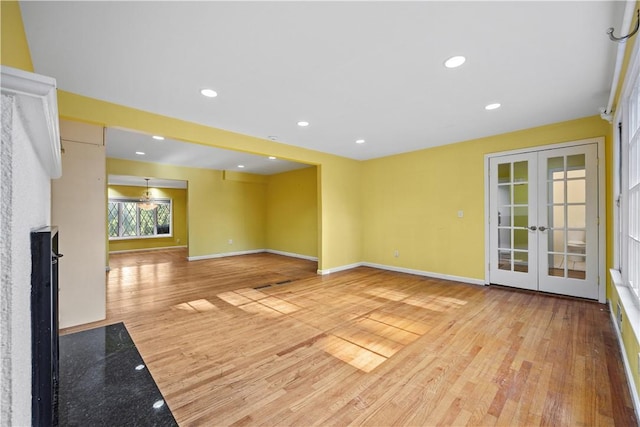 unfurnished living room with french doors and light hardwood / wood-style floors