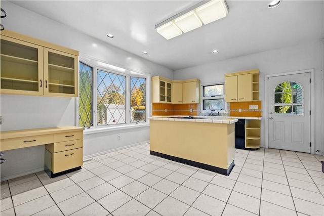 kitchen featuring sink, decorative backsplash, light tile patterned floors, tile counters, and a kitchen island