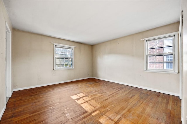 empty room featuring plenty of natural light and hardwood / wood-style floors